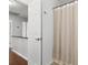 Well-lit bathroom with a white door, shower curtain, and wood-look floors at 115 Laurel Ridge Rd, North Charleston, SC 29418