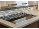 Close-up of kitchen island cooktop with tile backsplash and breakfast bar at 115 Laurel Ridge Rd, North Charleston, SC 29418