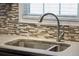 Close up image of stone countertop and sink with faucet and a view of window and decorative backsplash at 115 Laurel Ridge Rd, North Charleston, SC 29418