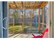 View of the screened porch, including a ceiling fan and red rocking chairs for comfortable outdoor living at 115 Laurel Ridge Rd, North Charleston, SC 29418
