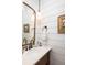 Charming bathroom features a wood-trimmed mirror, white vanity, and shiplap accent wall at 1302 Middle St, Sullivans Island, SC 29482
