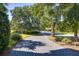 Paver driveway leading to a lush, landscaped property with mature trees at 1302 Middle St, Sullivans Island, SC 29482