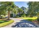 Elegant home with lush landscaping, a circular driveway, and palm trees at 1302 Middle St, Sullivans Island, SC 29482