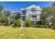 Stunning two-story white home with dual balconies, grand staircase, and lush lawn at 1302 Middle St, Sullivans Island, SC 29482