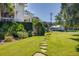 Landscaped front yard with a lush lawn, stone pathway, and charming exterior details of a pristine, well-maintained home at 1302 Middle St, Sullivans Island, SC 29482