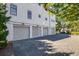 Spacious three-car garage with a brick driveway and modern doors, providing ample parking and curb appeal at 1302 Middle St, Sullivans Island, SC 29482