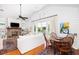 Open-concept living room with fireplace, dining area, and access to the balcony at 1302 Middle St, Sullivans Island, SC 29482