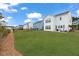 Expansive backyard featuring a well-maintained lawn and rear view of a white two-story home at 1530 Homecoming Blvd, Ravenel, SC 29470