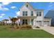 Charming two-story home features a manicured lawn, two-car garage, and a welcoming front porch at 1530 Homecoming Blvd, Ravenel, SC 29470