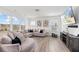 Bright living room with comfortable sectional, large windows, and hardwood flooring at 1530 Homecoming Blvd, Ravenel, SC 29470