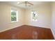 An empty bedroom is brightened by hardwood floors and two windows at 1637 Tatum St, Charleston, SC 29412