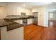 Open kitchen featuring stainless steel appliances, granite countertops, white cabinets, and beautiful hardwood floors at 1637 Tatum St, Charleston, SC 29412