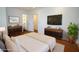 Beautiful main bedroom with wood floors, a modern dresser, a TV, and an ensuite bathroom at 1637 Tatum St, Charleston, SC 29412