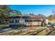 Exterior of home featuring an enclosed porch and shuttered windows, surrounded by mature trees and landscaping at 165 Infinity Dr, Dorchester, SC 29437