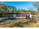 The home has a screened-in porch, shuttered windows, and a roof with a chimney nestled in a wooded area at 165 Infinity Dr, Dorchester, SC 29437