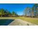 Spacious gravel parking area, surrounded by green lawn and mature trees at 165 Infinity Dr, Dorchester, SC 29437