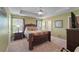 Main bedroom suite with tray ceilings, a ceiling fan, a large bed, and neutral carpeting at 1800 Poplar Grove Pl, Summerville, SC 29483