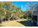 A picturesque view of the backyard with mature trees and a screened porch at 1810 Laura Creek Rd, Charleston, SC 29412