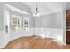 Bright dining room featuring hardwood floors, wainscoting, and ample natural light from large windows with modern shutters at 1810 Laura Creek Rd, Charleston, SC 29412