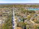 A neighborhood is captured from above, surrounded by tall trees and a winding road with a serene lake in the background at 1874 Rifle Range Rd, Mount Pleasant, SC 29464