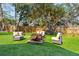 Spacious backyard with artificial turf, mature tree, fire pit, and outdoor seating area at 1874 Rifle Range Rd, Mount Pleasant, SC 29464
