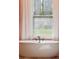 A modern bathtub in a serene, light-filled bathroom, offering a relaxing view of the outdoors at 1874 Rifle Range Rd, Mount Pleasant, SC 29464