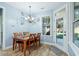 Light and airy dining room with wood floors, wood table, and door to backyard at 1874 Rifle Range Rd, Mount Pleasant, SC 29464