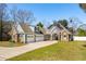 Inviting two-story home featuring stone accents, solar panels, a three-car garage, and a well-kept lawn at 1874 Rifle Range Rd, Mount Pleasant, SC 29464