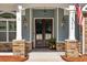 Inviting front entrance featuring a covered porch, stone accents, and a beautifully designed double door entry at 1874 Rifle Range Rd, Mount Pleasant, SC 29464