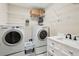 Bright laundry room featuring a front load washer, dryer, wire shelving, and a sink with granite countertop at 1874 Rifle Range Rd, Mount Pleasant, SC 29464