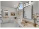 Bright bathroom with marble floors, soaking tub, double vanity, and large arched window at 1988 Long Creek Rd, Wadmalaw Island, SC 29487