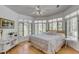 Light-filled bedroom featuring a ceiling fan, neutral decor, and panoramic windows with backyard views at 1988 Long Creek Rd, Wadmalaw Island, SC 29487