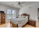 Bedroom features a patterned bed, hardwood floors, and a bright window view at 1988 Long Creek Rd, Wadmalaw Island, SC 29487