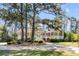 Stunning exterior elevation of home surrounded by mature trees and lush landscaping at 1988 Long Creek Rd, Wadmalaw Island, SC 29487