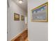 Hallway with hardwood floors, neutral paint, and decorative artwork on the wall at 1988 Long Creek Rd, Wadmalaw Island, SC 29487
