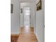 Hallway with hardwood floors and decorative art, leading to a bright bathroom at 1988 Long Creek Rd, Wadmalaw Island, SC 29487