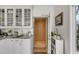 Elegant kitchen with white cabinetry, granite countertops, and a door to the life boat room at 1988 Long Creek Rd, Wadmalaw Island, SC 29487