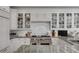 Bright kitchen features custom white cabinets, granite countertops, and stainless steel Wolf oven and cooktop at 1988 Long Creek Rd, Wadmalaw Island, SC 29487