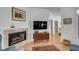 Living room with a fireplace, hardwood floors, and view into hall at 1988 Long Creek Rd, Wadmalaw Island, SC 29487