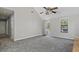 Bright bedroom with gray carpet, ceiling fan, and natural light from windows and glass door at 201 Commons Way, Goose Creek, SC 29445