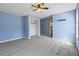 Spacious blue bedroom with gray carpet, a walk-in closet, and a doorway to the bathroom at 201 Commons Way, Goose Creek, SC 29445