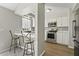 Well-lit kitchen featuring stainless steel appliances, gray backsplash, white cabinetry, and a breakfast bar at 201 Commons Way, Goose Creek, SC 29445