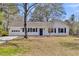 Charming one-story home with freshly painted white brick and dark blue shutters at 202 Basswood Ave, Summerville, SC 29483