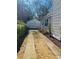 Driveway leading to a detached garage, framed by established landscaping, and home siding, showcasing curb appeal at 2433 Fulford Ct, Mount Pleasant, SC 29466