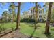 Back exterior featuring a screened porch and back balconies, with lush greenery and trees at 2440 Cat Tail Pond Rd, Seabrook Island, SC 29455