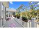Inviting balcony with white railings, pink rugs, and flower boxes offering serene views of the surrounding lush greenery at 2440 Cat Tail Pond Rd, Seabrook Island, SC 29455