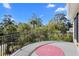 Balcony featuring iron railing with a pink rug and views of lush, mature trees and blue sky at 2440 Cat Tail Pond Rd, Seabrook Island, SC 29455