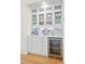 Stylish bar area with glass-front cabinets, a beverage refrigerator, and ample counter space for entertaining at 2440 Cat Tail Pond Rd, Seabrook Island, SC 29455