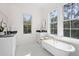 Elegant bathroom featuring a clawfoot tub, marble countertop, and bright natural light at 2440 Cat Tail Pond Rd, Seabrook Island, SC 29455