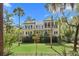 Charming exterior with double balconies, a screened porch, and beautiful tropical landscaping at 2440 Cat Tail Pond Rd, Seabrook Island, SC 29455